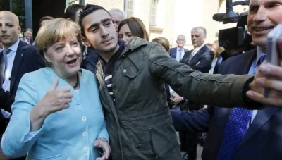صاحب أشهر صورة مع المستشارة أنجيلا ميركل يحصل على الجنسية الألمانية